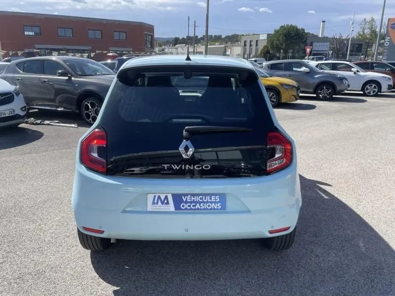 Vue arrière d'une Renault Twingo III bleu dragée 2022 avec logo et plaque "Véhicules Occasions" visible.