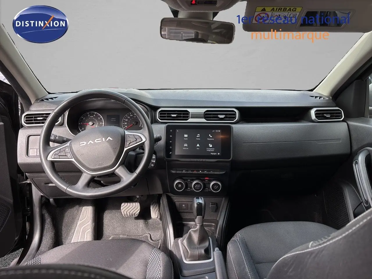 Vue intérieure avant du tableau de bord et volant noir du Dacia Duster Journey TCe 150 EDC 2024 avec écran tactile central.