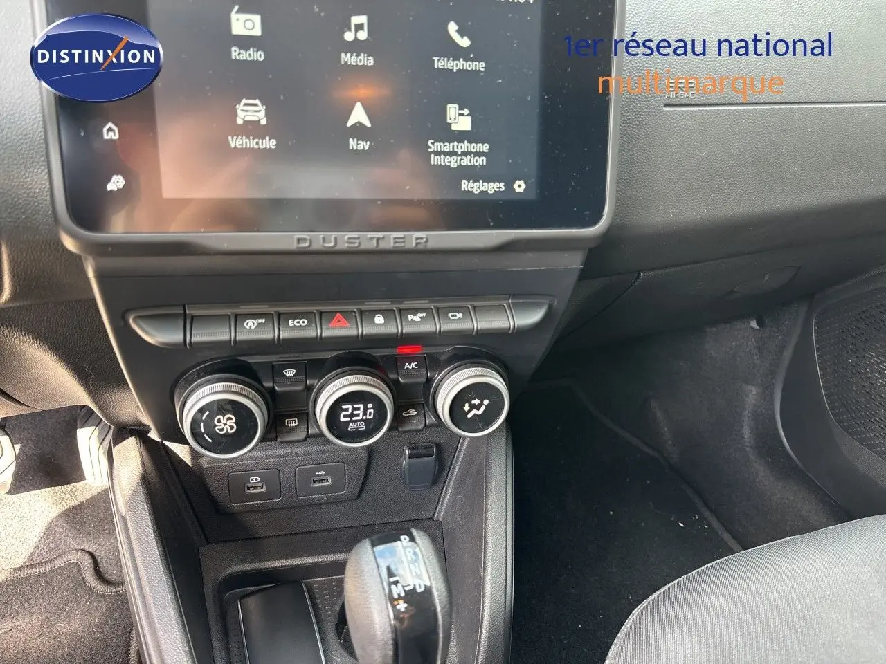 Intérieur du Dacia Duster noir 2024, vue sur la console centrale avec écran tactile et commande de climatisation digitale.