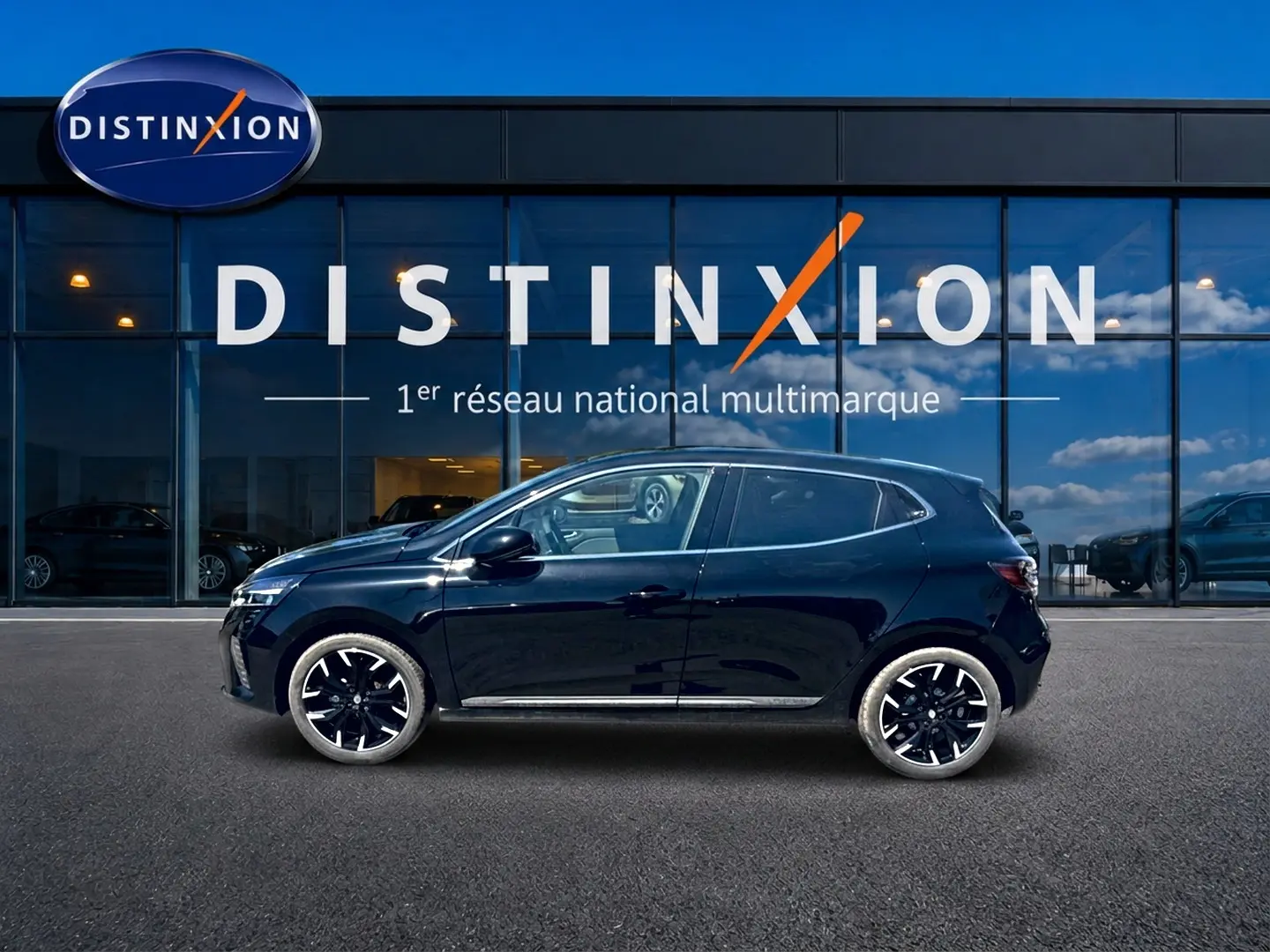 Profil côté gauche de la Renault Clio V noire 2025 avec jantes alu noires, devant une vitrine Distinxion.