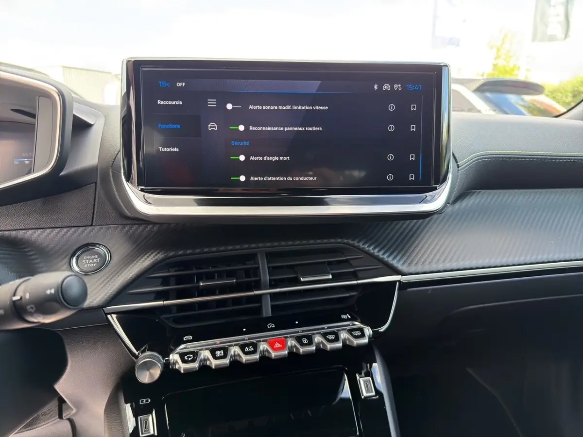 Vue intérieure du tableau de bord du Peugeot 2008 Hybrid 145 e-DCS6 GT 2026 avec écran tactile central et commandes piano noir.