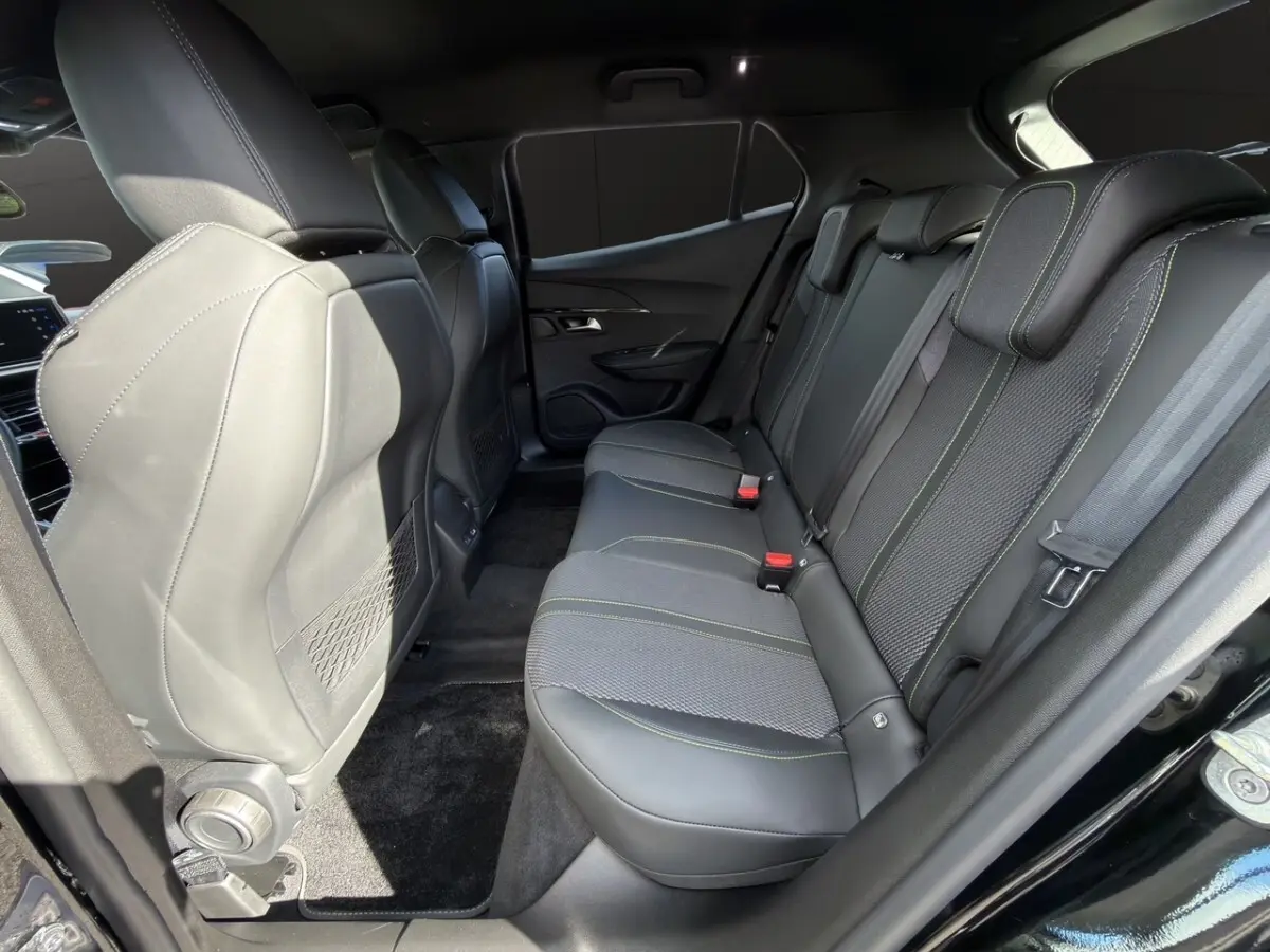Vue intérieure côté droit sur la banquette arrière noire avec surpiqûres vertes du Peugeot 2008 Hybrid 145 e-DCS6 GT 2026.
