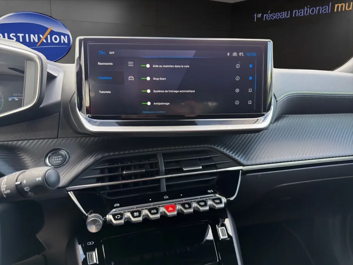 Intérieur du tableau de bord du Peugeot 2008 Hybrid 145 e-DCS6 GT avec écran tactile central et commandes piano noires.