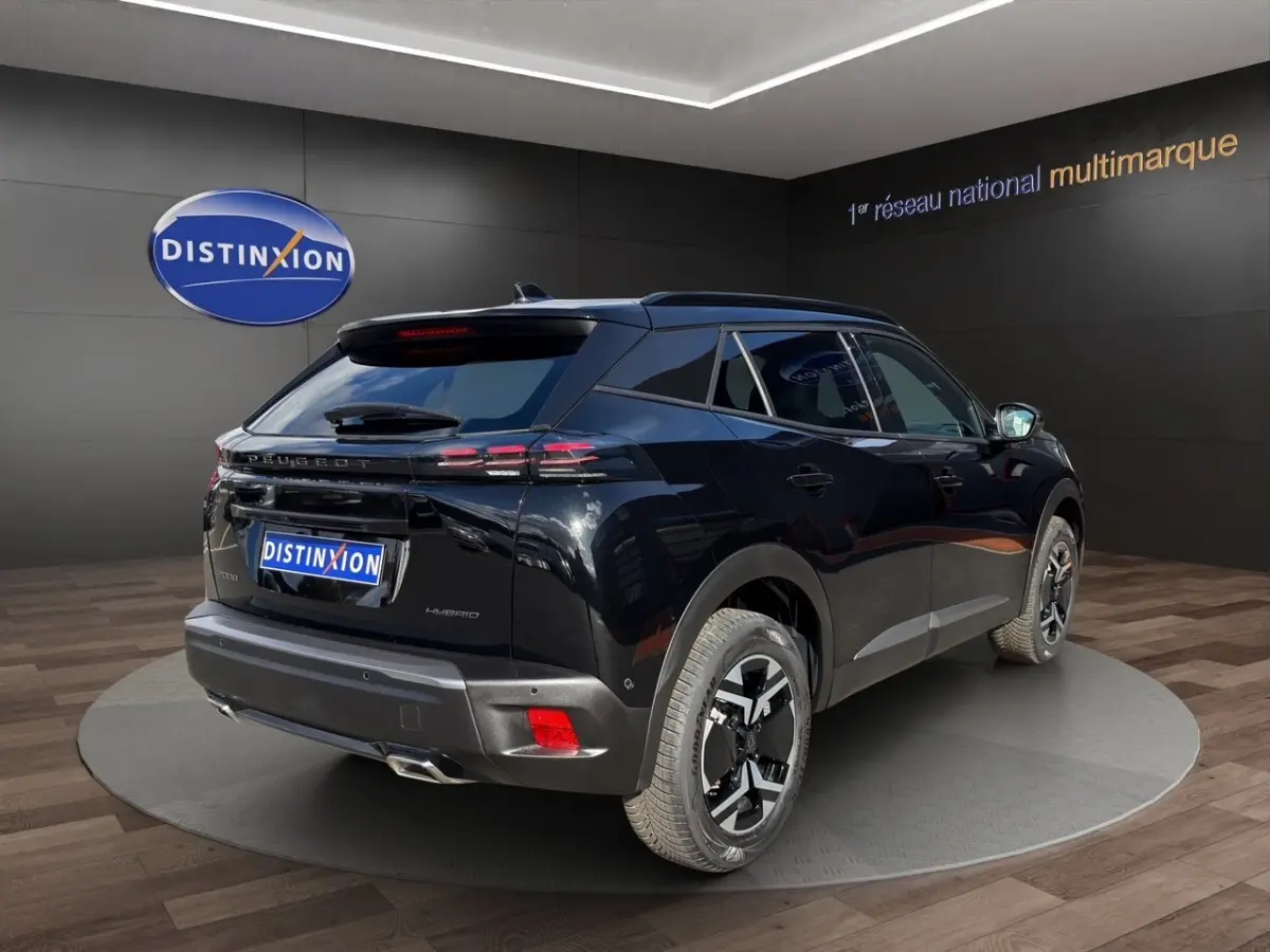 Vue 3/4 arrière droite d’un Peugeot 2008 Hybrid 145 e-DCS6 GT noir avec feux LED et jantes distinctives.