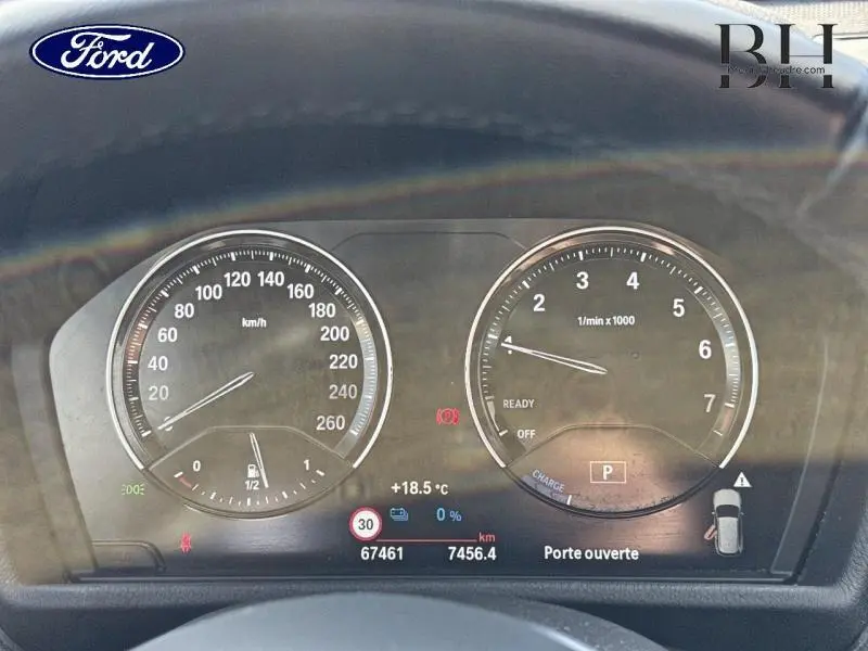 Tableau de bord BMW X1 xDrive25eA 220ch xLine 2021 en Saphirschwarz, affichage digital du compteur et alertes visibles.