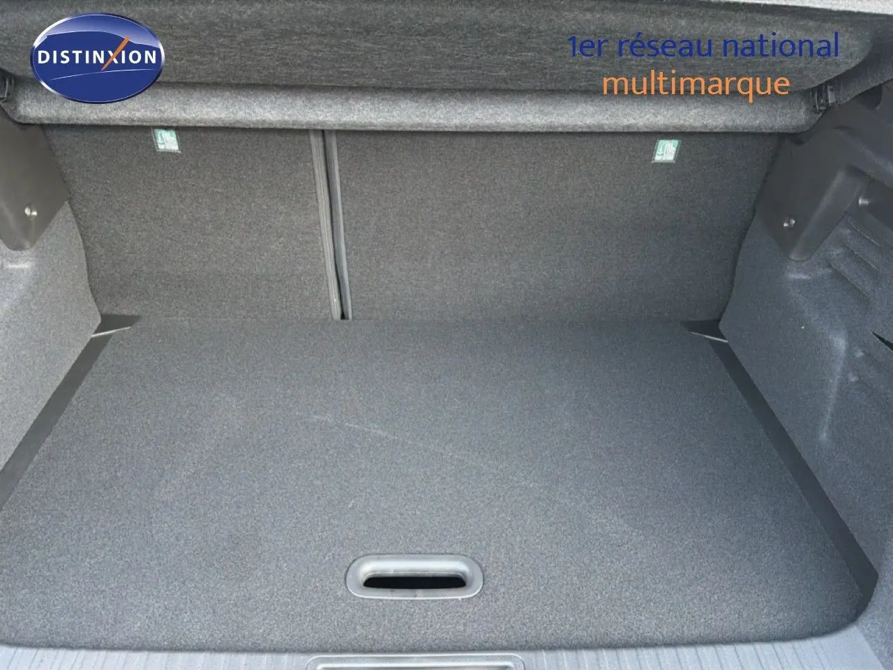 Vue intérieure du coffre spacieux et tapissé en gris foncé du Renault Captur blanc nacré 2025, version hybride.