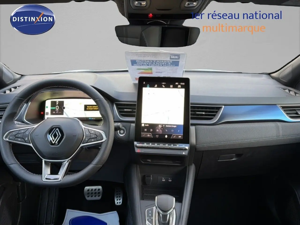 Vue intérieure avant du Renault Captur 1.6 E-TECH hybride 2025, tableau de bord moderne avec écran tactile vertical et volant multifonction.