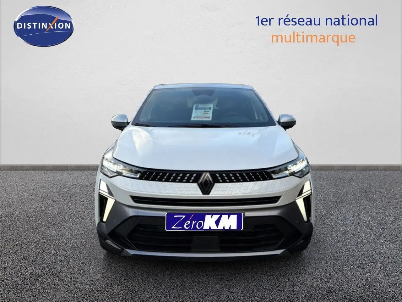 Vue frontale du Renault Captur 2025 blanc nacré avec toit gris, mettant en valeur ses phares LED et sa calandre distinctive.