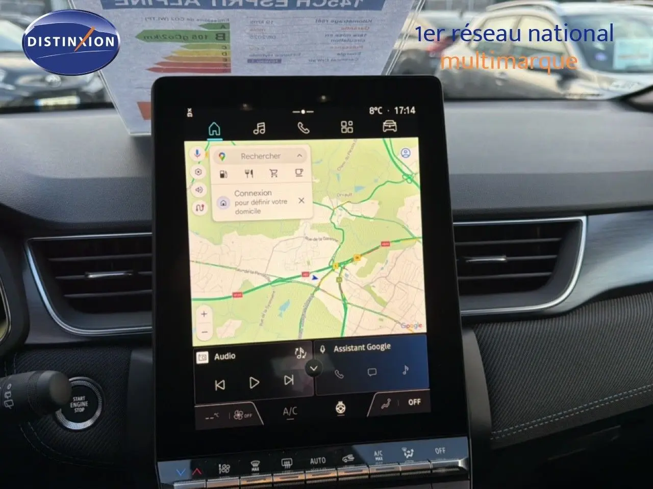 Vue intérieure centrée sur l'écran tactile du tableau de bord du Renault Captur blanc nacré avec toit gris, affichant la navigation.