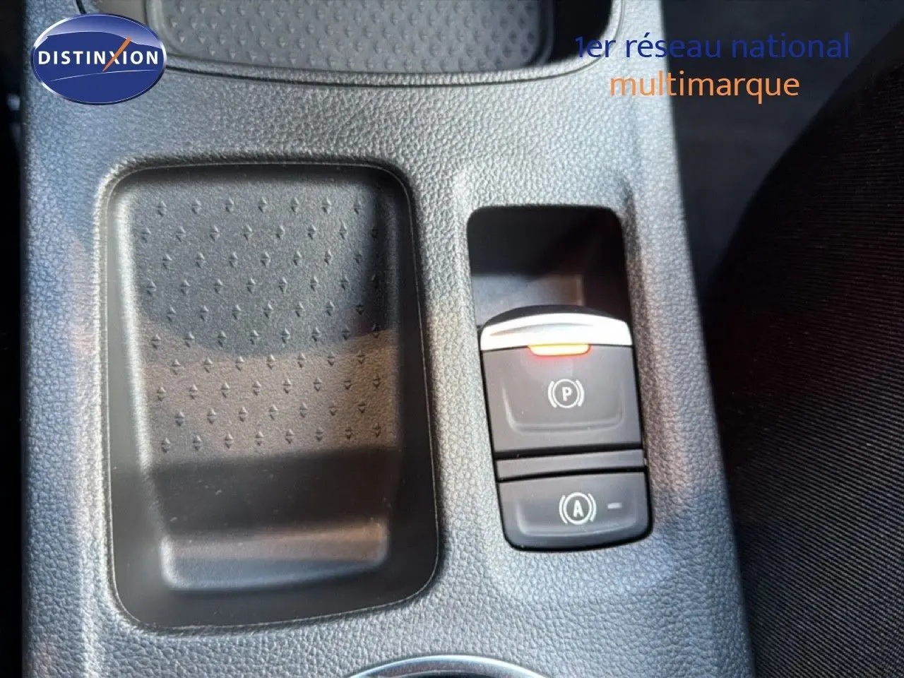 Gros plan sur la console centrale du Renault Captur 2025, montrant les commandes de frein à main électrique et d'assistance au démarrage.