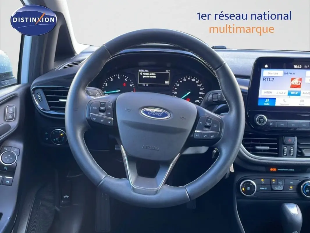 Vue intérieure centrée sur le volant noir de la Ford Fiesta 2020 avec tableau de bord et écran tactile visible.