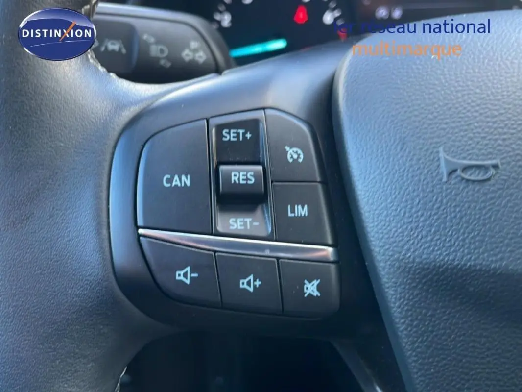 Gros plan sur les commandes du régulateur de vitesse au volant d’une Ford Fiesta blanche de 2020.