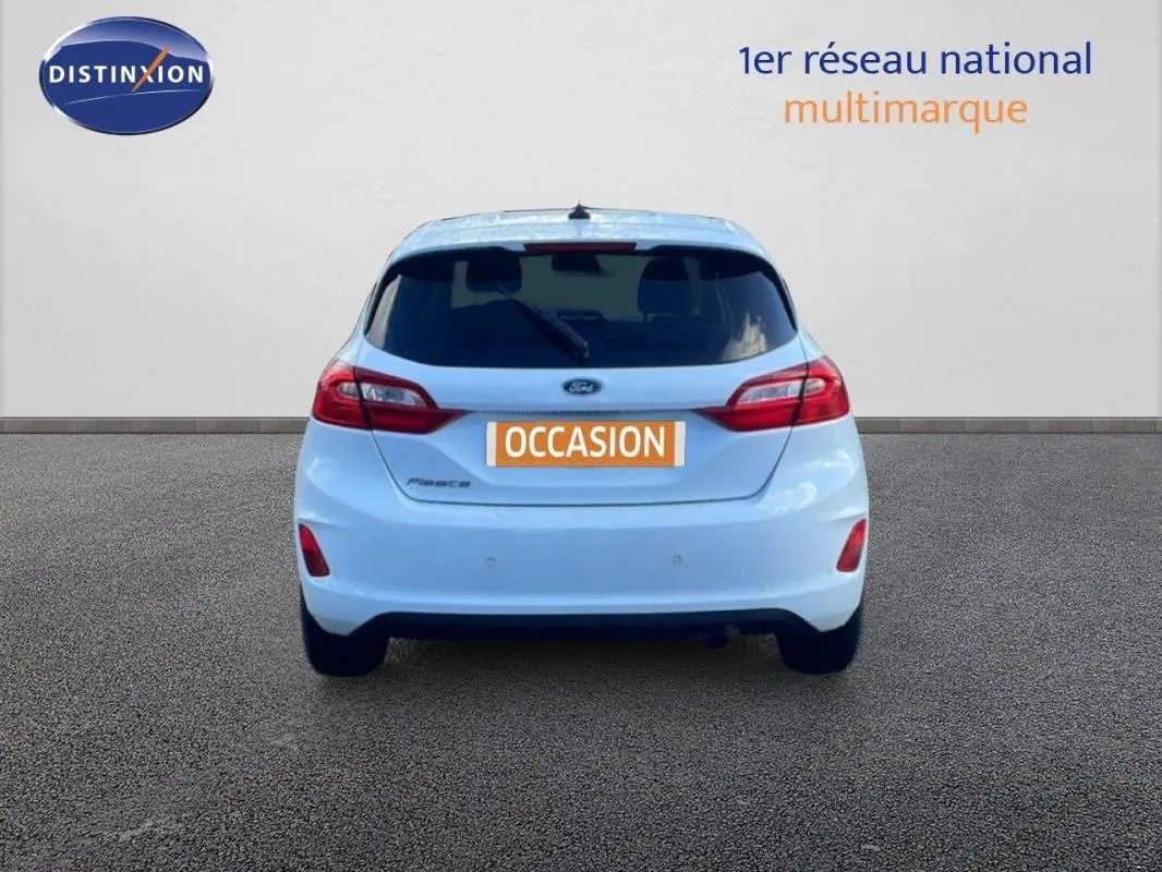 Vue arrière d'une Ford Fiesta blanche 2020 avec vitres surteintées et plaque d'immatriculation "OCCASION".