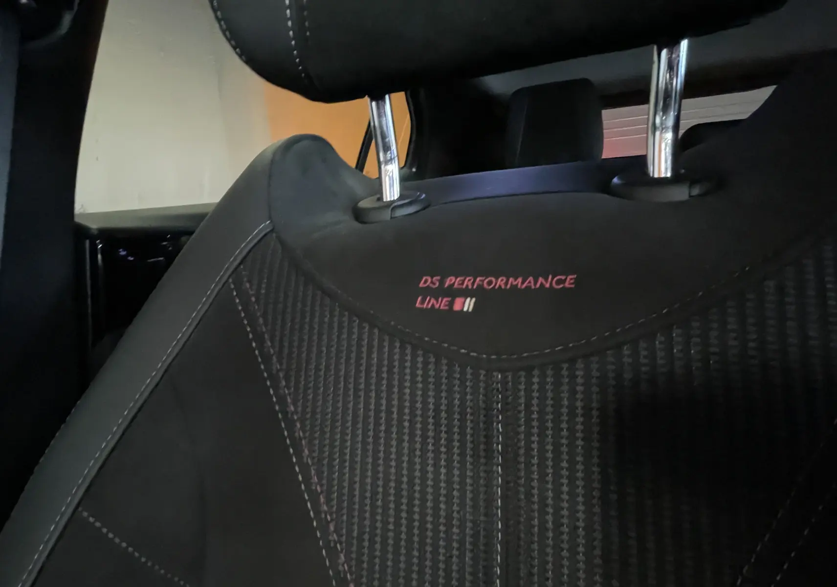 Gros plan sur l'appui-tête avant avec broderie "DS Performance Line" sur sellerie tissu tressé Basalte et Alcantara noir.