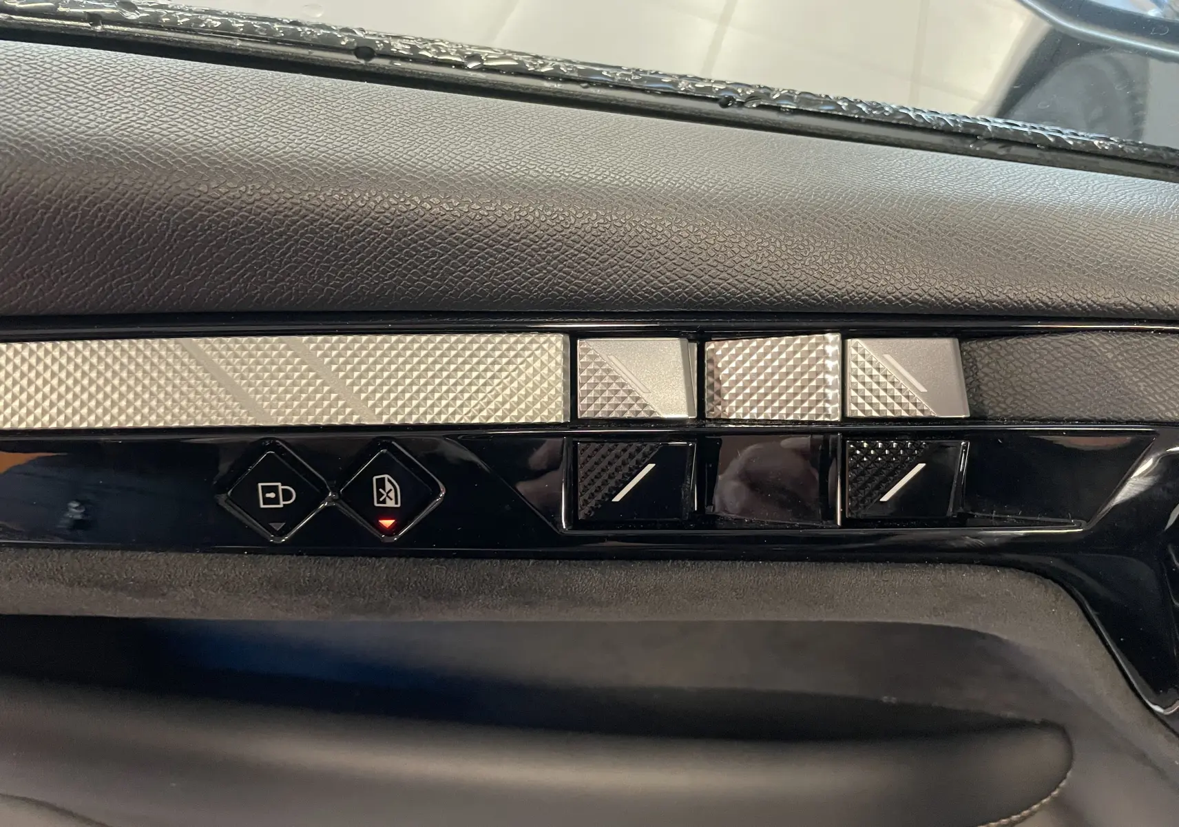 Détail des commandes de porte côté conducteur du DS4 2024 gris platinium, avec boutons de verrouillage et réglages des vitres.