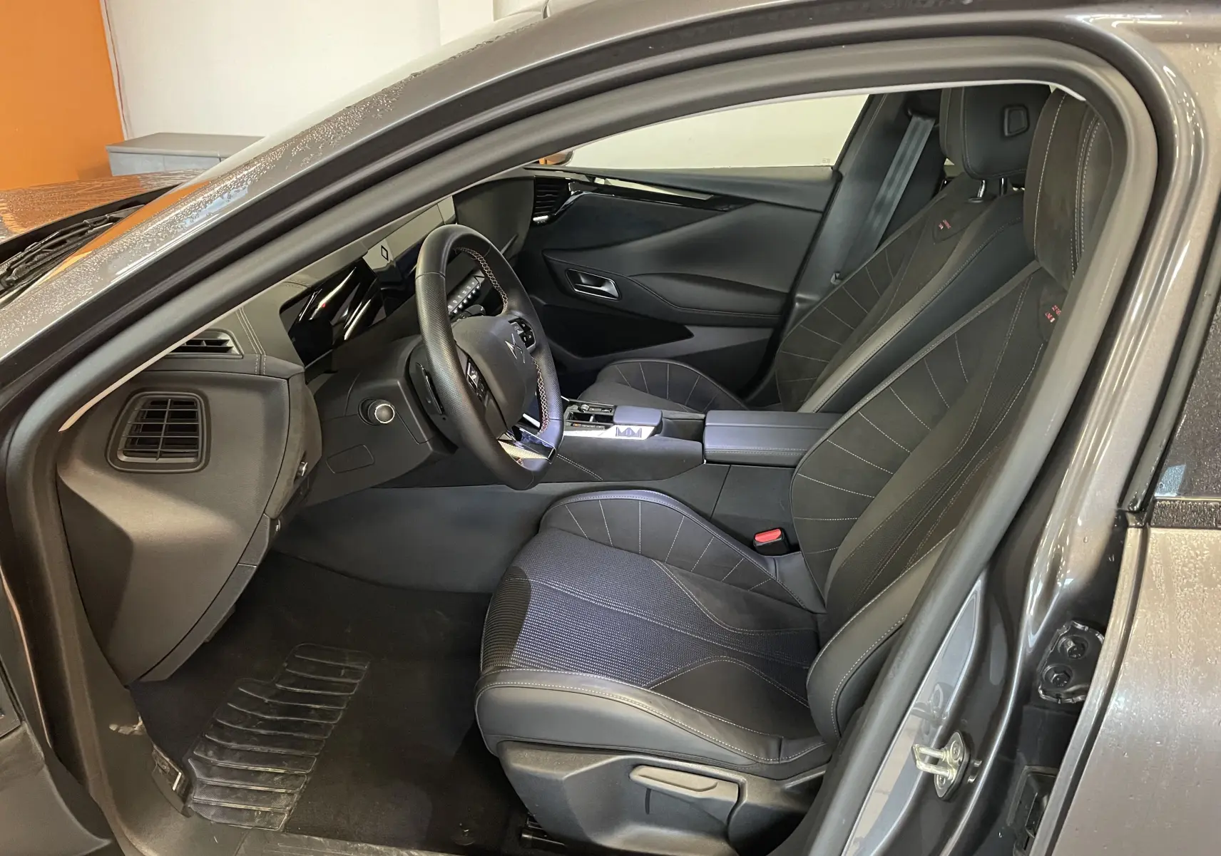 Intérieur avant droit du DS4 gris platinium 2024, sièges tissu tressé et alcantara, volant cuir et console centrale moderne.