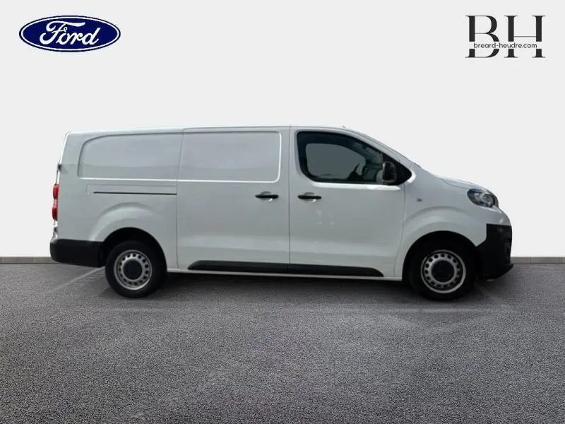 Profil droit d'un utilitaire blanc banquise PEUGEOT Expert Fourgon Long 2020 avec portes latérales et jantes acier noires.