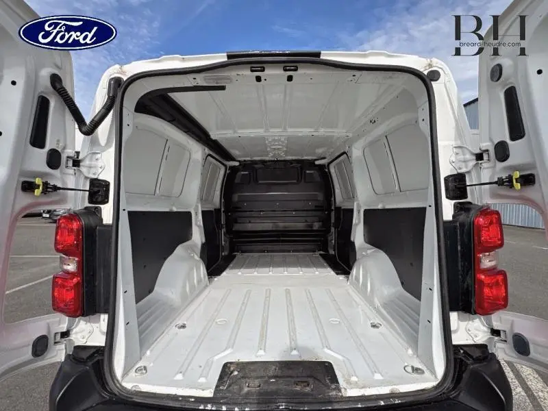 Vue arrière ouverte du fourgon blanc banquise Peugeot Expert Long 2020 montrant l'espace de chargement vide et la cloison noire.