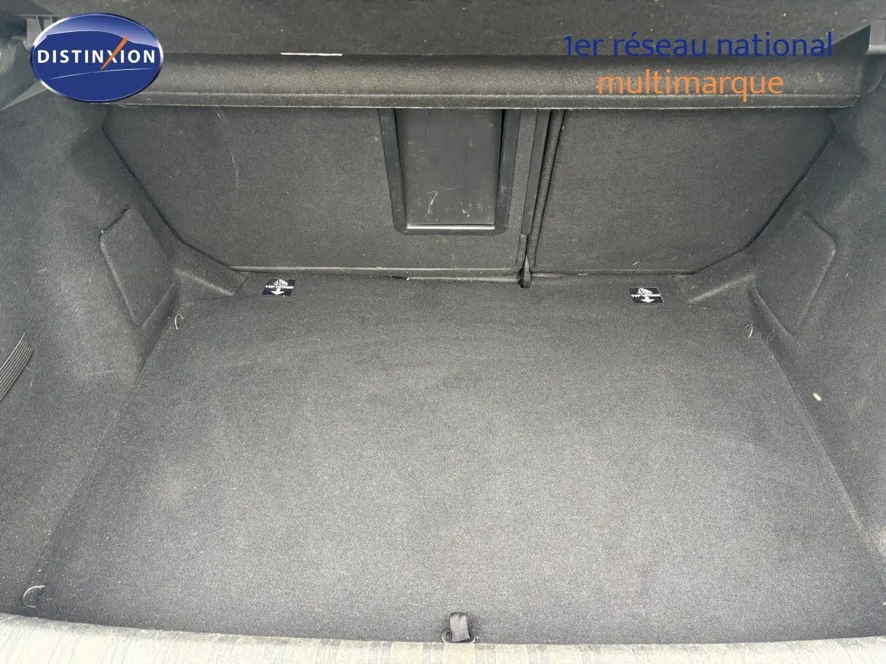 Coffre vide en vue plongeante d'une Peugeot 308 Bleu Magnetic, soulignant l'espace de rangement intérieur.