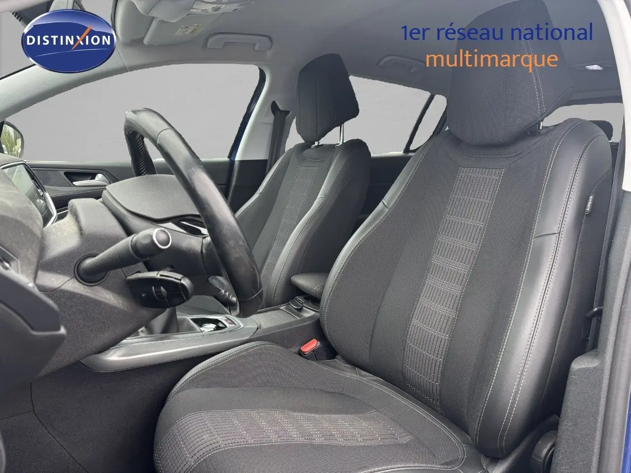 Vue intérieure des sièges avant en tissu noir et tableau de bord partiel d'une Peugeot 308 Bleu Magnetic de 2020.