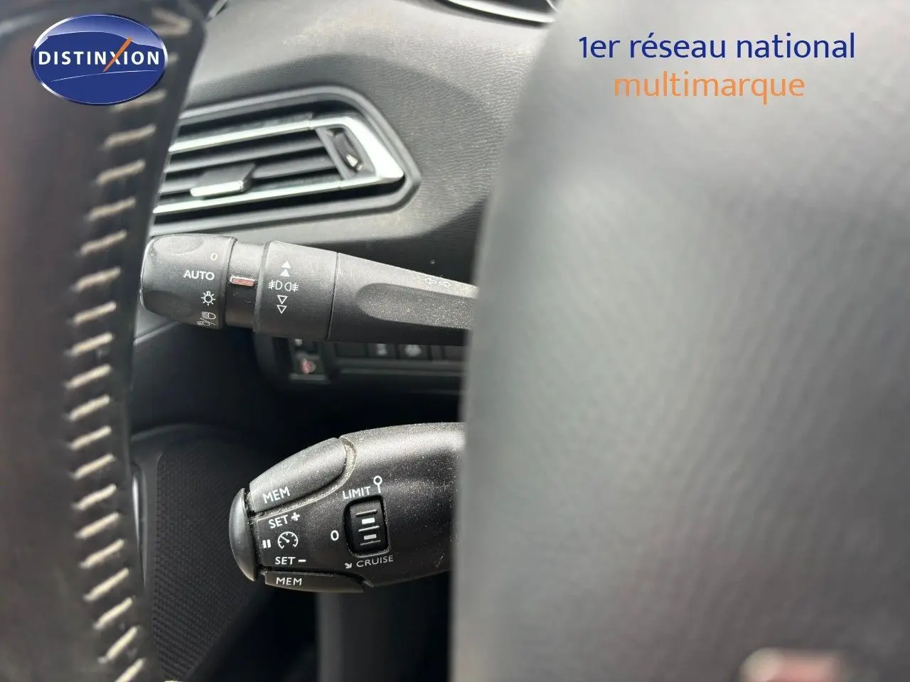 Gros plan sur les commandes de régulateur et feux au volant d'une Peugeot 308 Bleu Magnetic, version 2020.