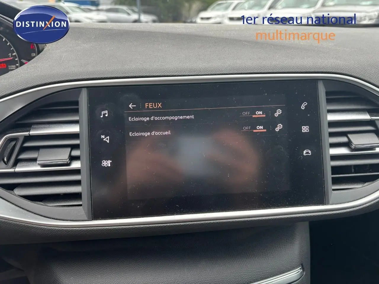 Écran tactile central du tableau de bord de la Peugeot 308 Bleu Magnetic, affichant les réglages des feux d’éclairage d’accompagnement et d’accueil.