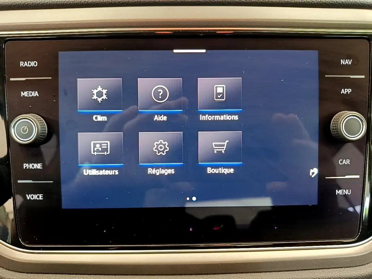 Écran tactile central du Volkswagen T-Roc 2021 affichant les options climatisation, aide, informations, utilisateurs, réglages et boutique.