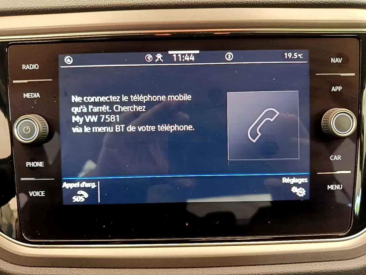 Écran tactile central du Volkswagen T-Roc 2.0 TDI blanc, affichant les instructions de connexion Bluetooth.