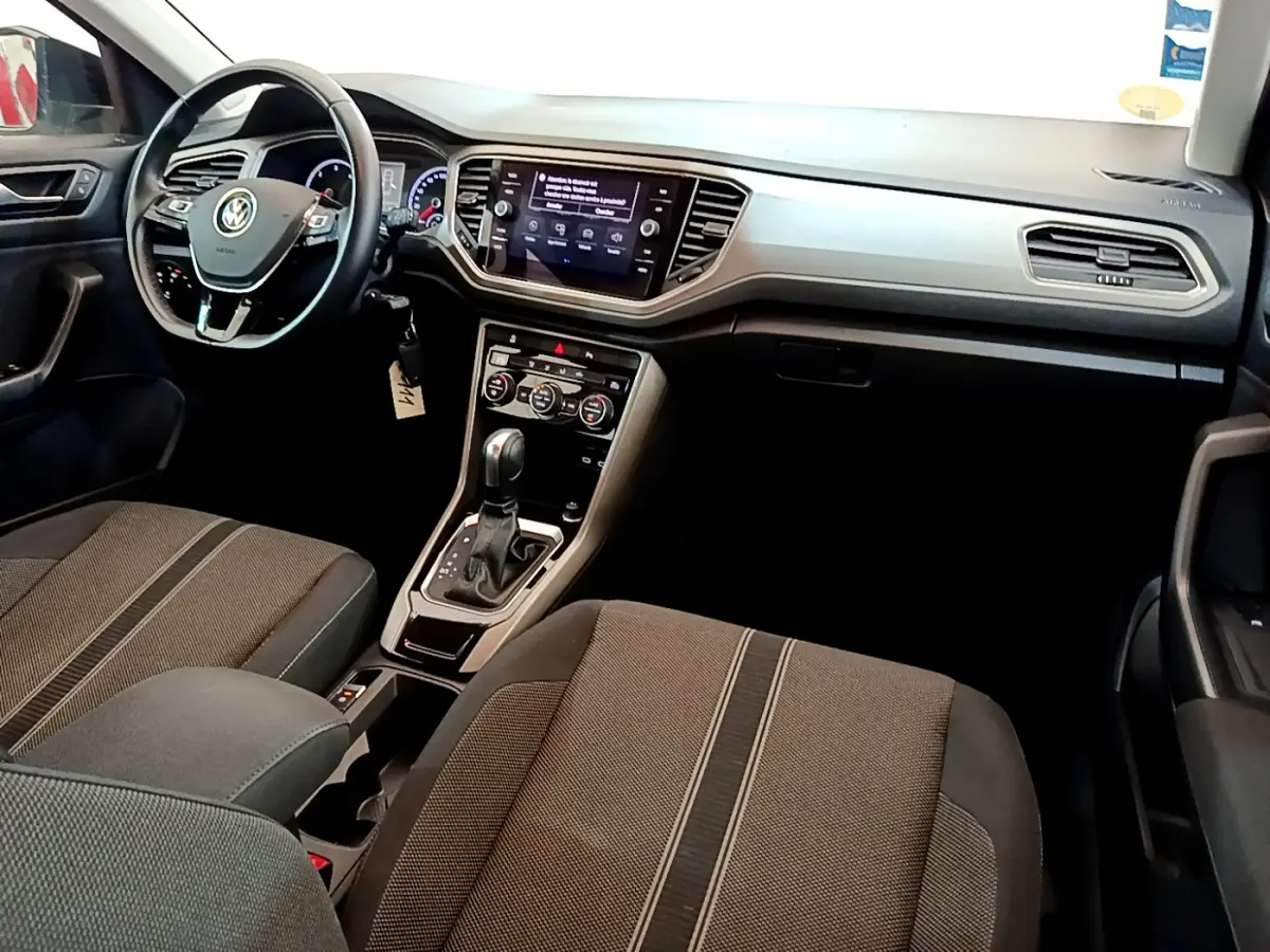 Intérieur Volkswagen T-Roc 2021 vu côté conducteur, tableau de bord moderne avec écran tactile et sièges tissu gris.