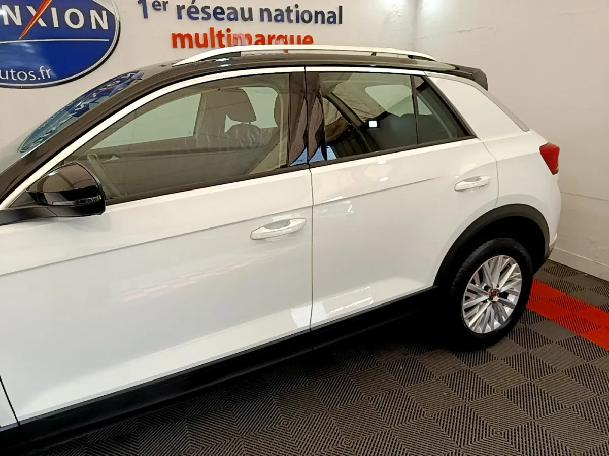 Profil côté gauche blanc du Volkswagen T-Roc 2021 avec rétroviseurs noirs et jantes alliage multibranches