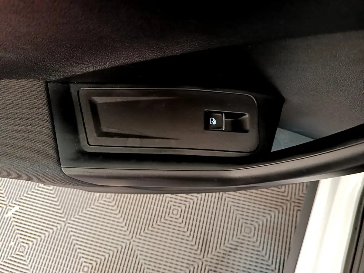 Détail de la poignée intérieure de déverrouillage de porte sur la portière côté gauche d'un Volkswagen T-Roc blanc 2021.