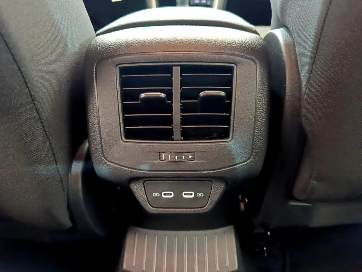 Gros plan sur la ventilation arrière et deux ports USB-C noirs entre les sièges avant du Volkswagen T-Roc blanc.