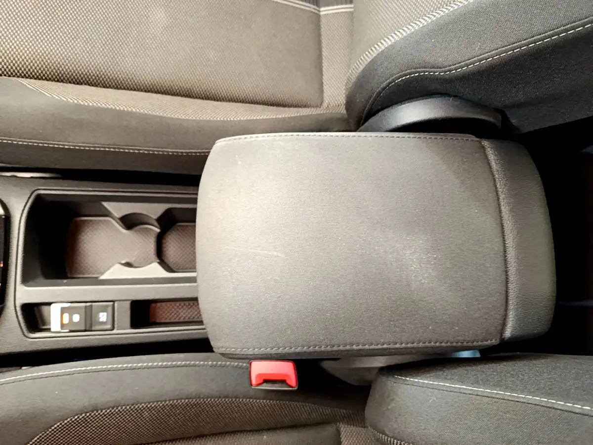 Accoudoir central en tissu gris avec porte-gobelets et bouton frein à main électrique dans Volkswagen T-Roc blanc 2021.