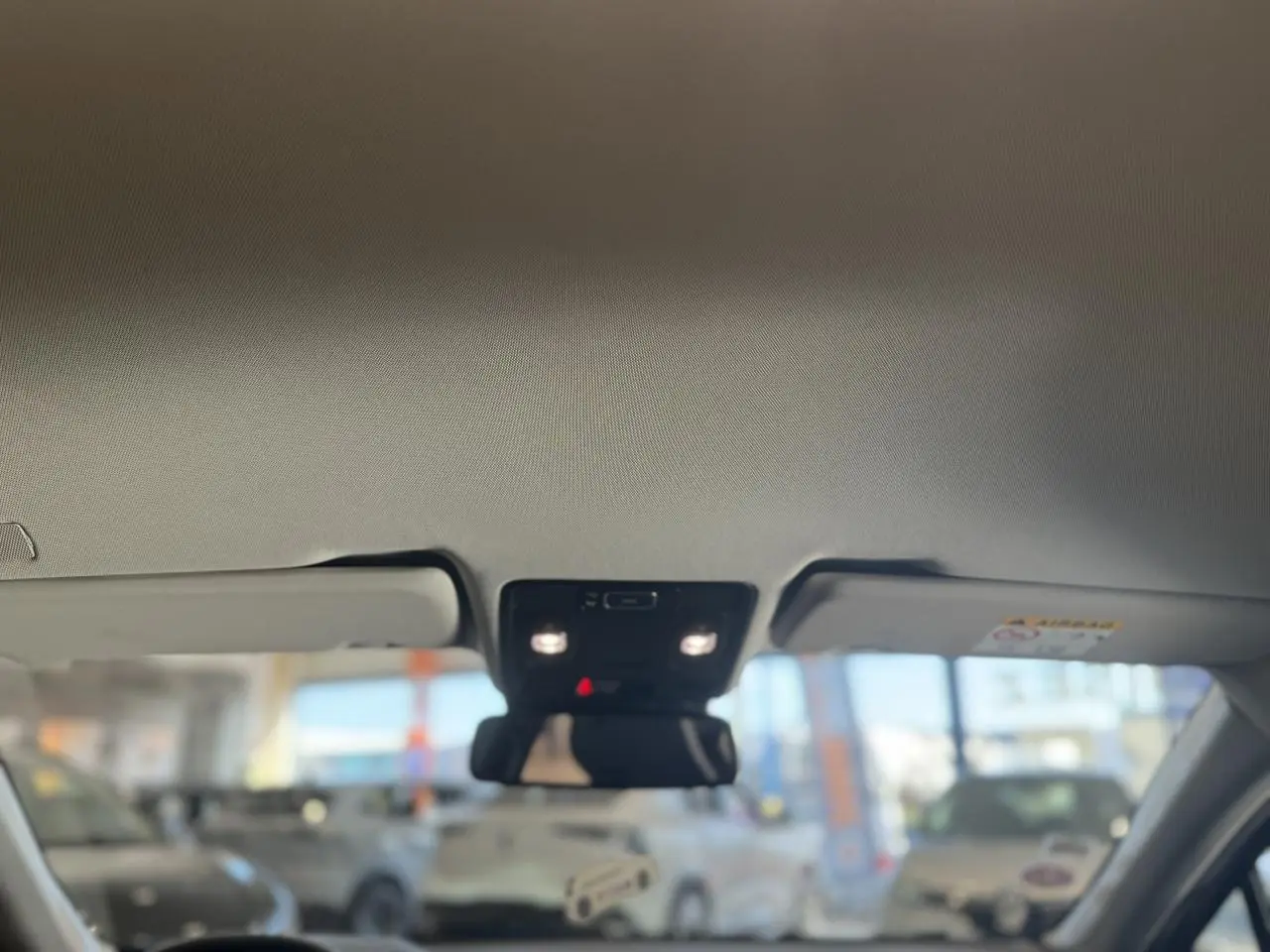 Vue intérieure du toit ouvrant électrique avec pare-soleil et éclairage, sur Renault Captur rouge foncé 2020 Intens.