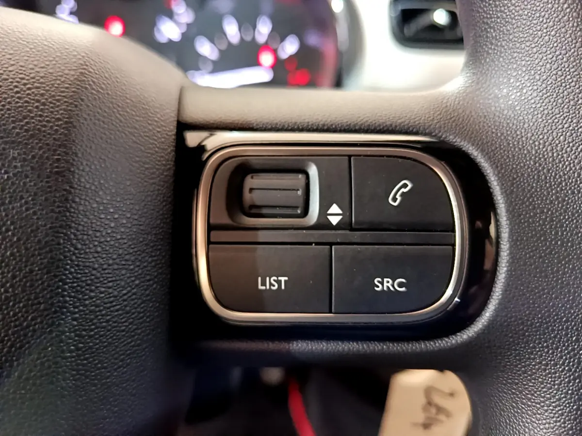 Gros plan sur les commandes multifonctions noires du volant de la Citroën C3 PureTech 68 BVM Live 2018.