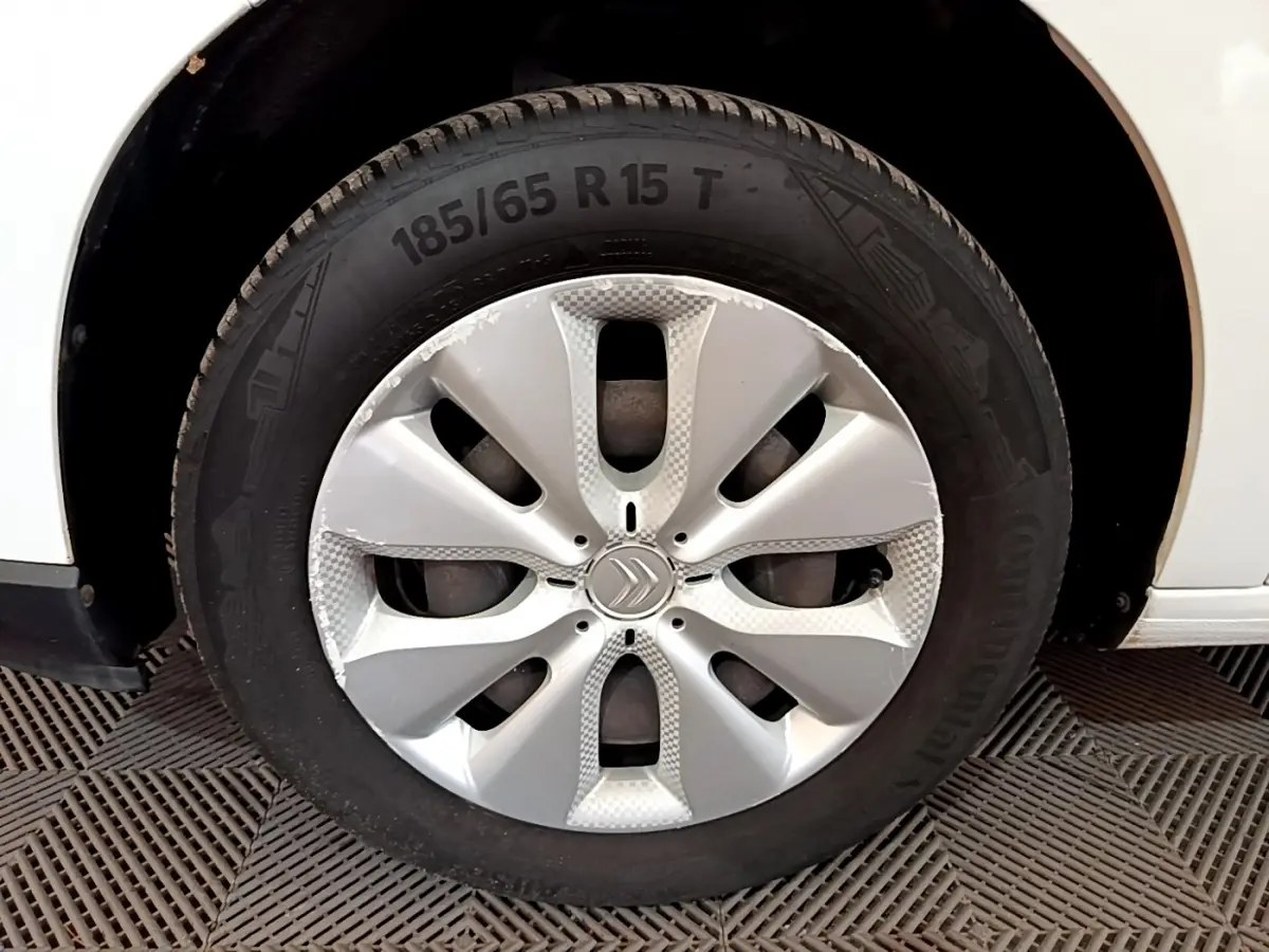 Gros plan sur la roue avant droite d'une Citroën C3 blanche avec jante argentée et logo Citroën central.