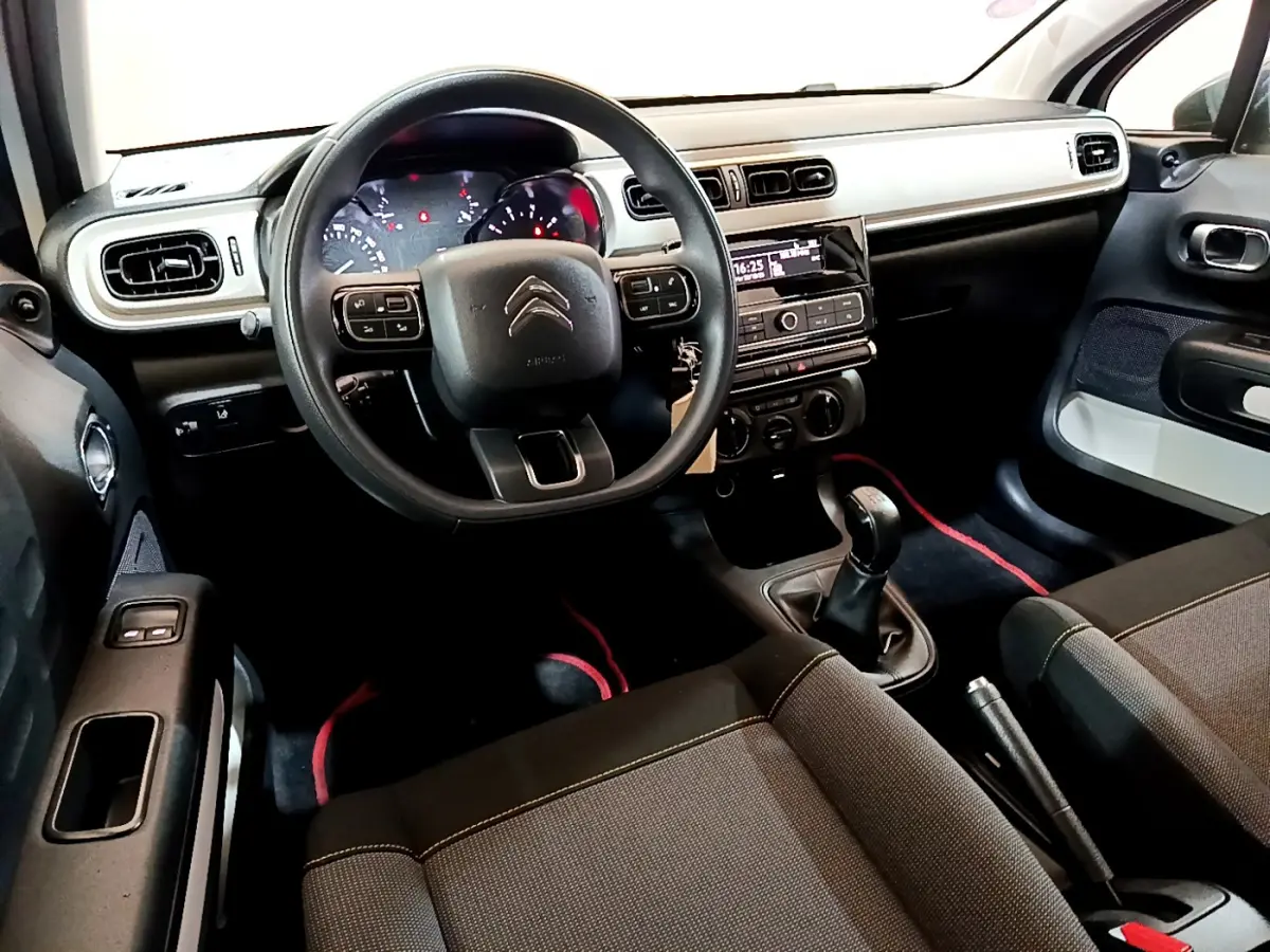 Intérieur avant de la Citroën C3 PureTech 68 BVM Live 2018, vue côté conducteur, tableau de bord clair et sièges noirs.