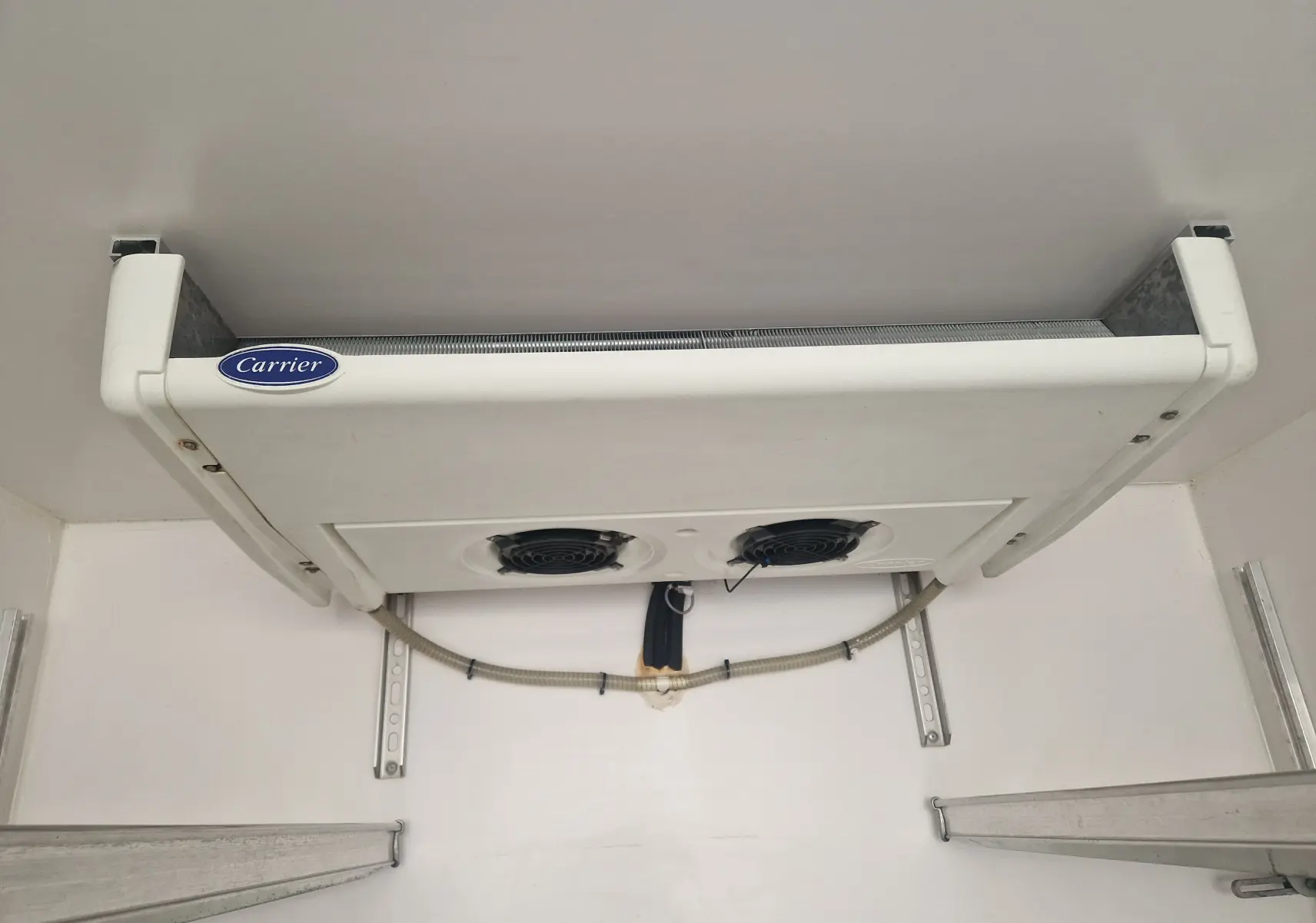 Vue intérieure du groupe frigorifique Carrier blanc fixé au plafond de la cellule isotherme du Renault Master Plancher Cabine blanc.