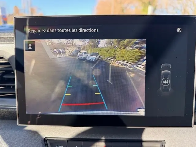 Écran tactile intérieur montrant la caméra de recul avec vue arrière et lignes de guidage colorées du Renault Master blanc.