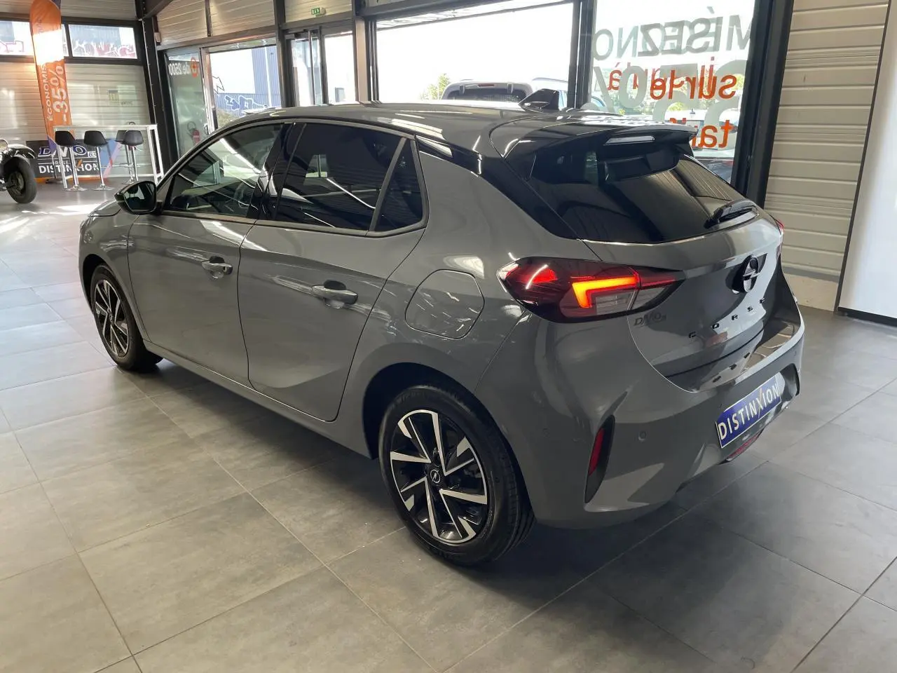 Vue 3/4 arrière droite d'une Opel Corsa gris Grafik avec feux LED et jantes alliage diamantées en showroom.