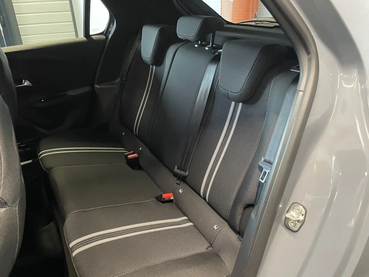 Vue côté droit de la banquette arrière noire avec surpiqûres blanches dans une Opel Corsa gris clair 2026.