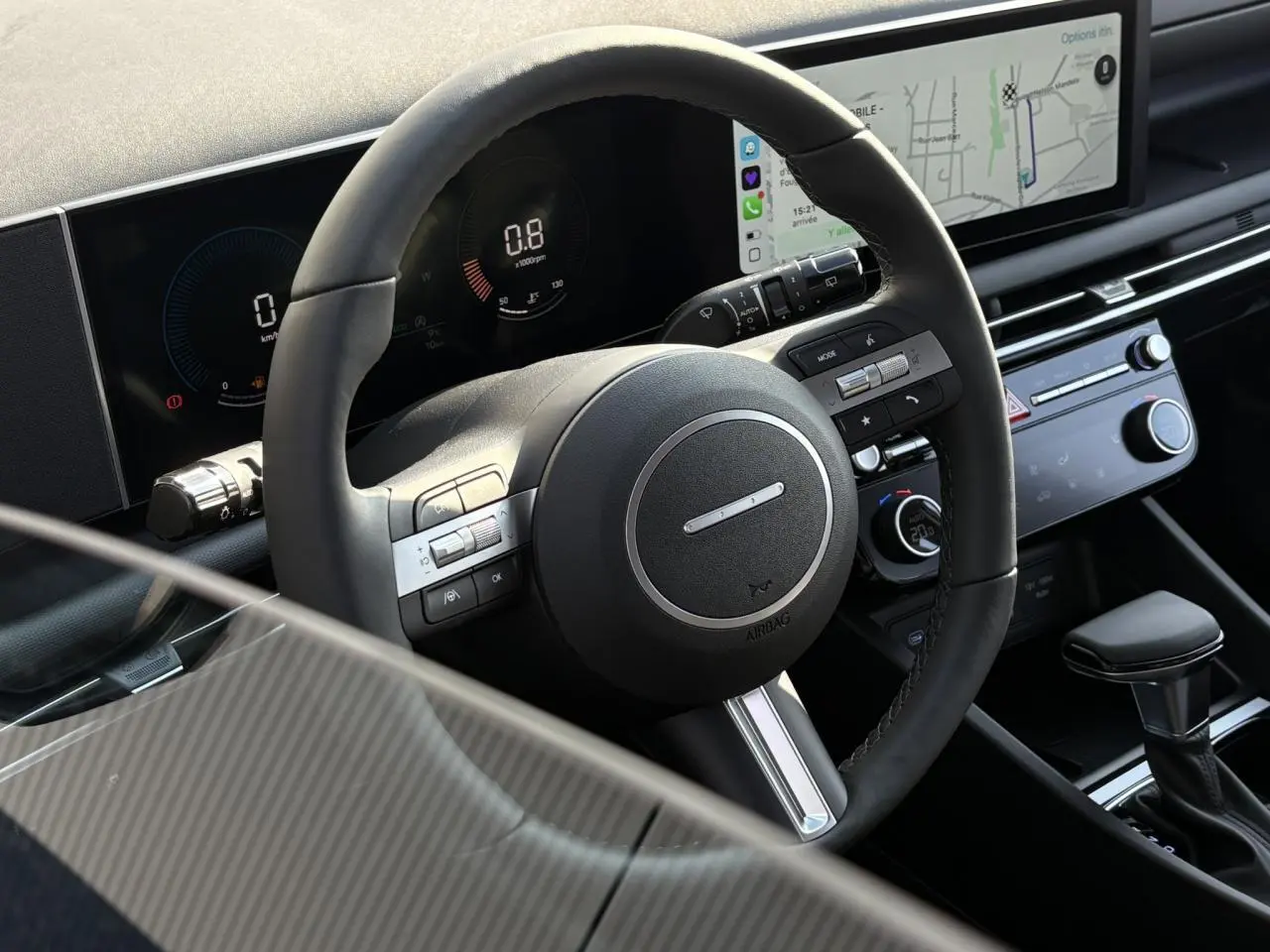 Vue rapprochée du volant cuir et du tableau de bord numérique du Hyundai Tucson 2025, avec écran tactile et commandes intégrées.