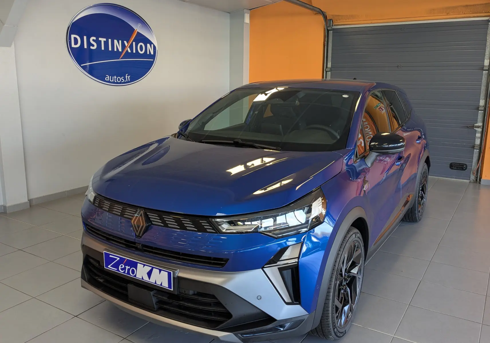 Renault Symbioz E-Tech hybride bleu Iron en 3/4 avant droit, avec calandre noire et jantes biton modernes.