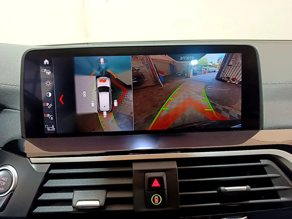 Écran tactile intérieur montrant la caméra de recul et la vue 360° du BMW X3 noir en stationnement.