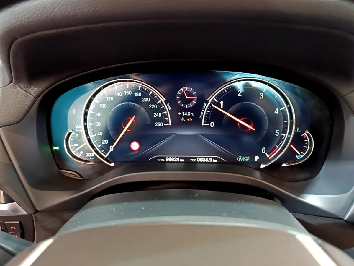 Tableau de bord numérique de BMW X3 noir, affichage vitesse, compte-tours et température extérieure à 14°C.