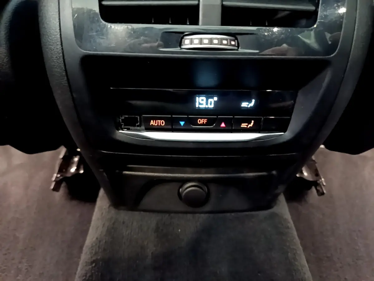 Gros plan sur la commande de climatisation arrière digitale affichant 19°C dans un BMW X3 noir 2019.