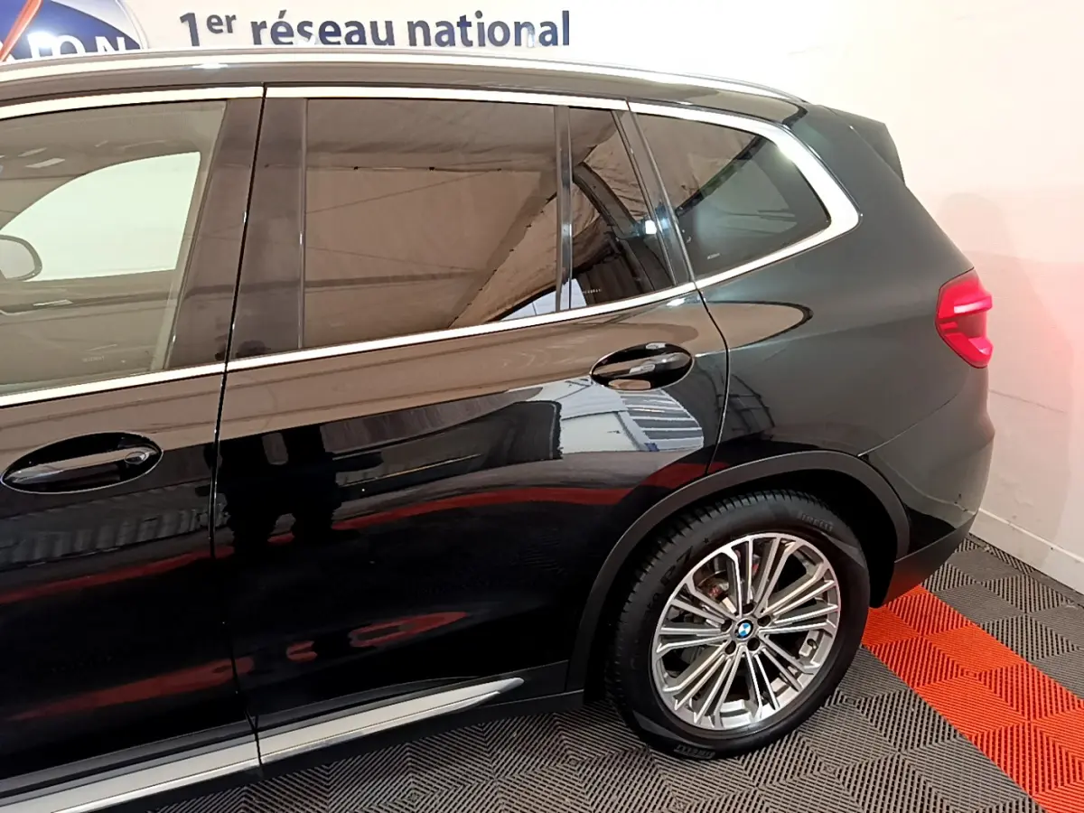 Vue latérale côté droit d’un BMW X3 noir 2019, mettant en valeur la jante alliage et les lignes élégantes du SUV.