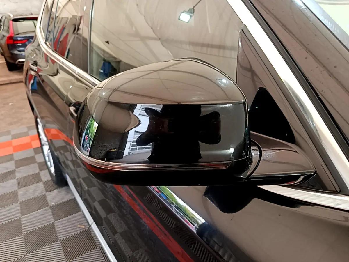 Rétroviseur côté gauche noir brillant d’un BMW X3 2019, avec reflet et entourage chromé visible.