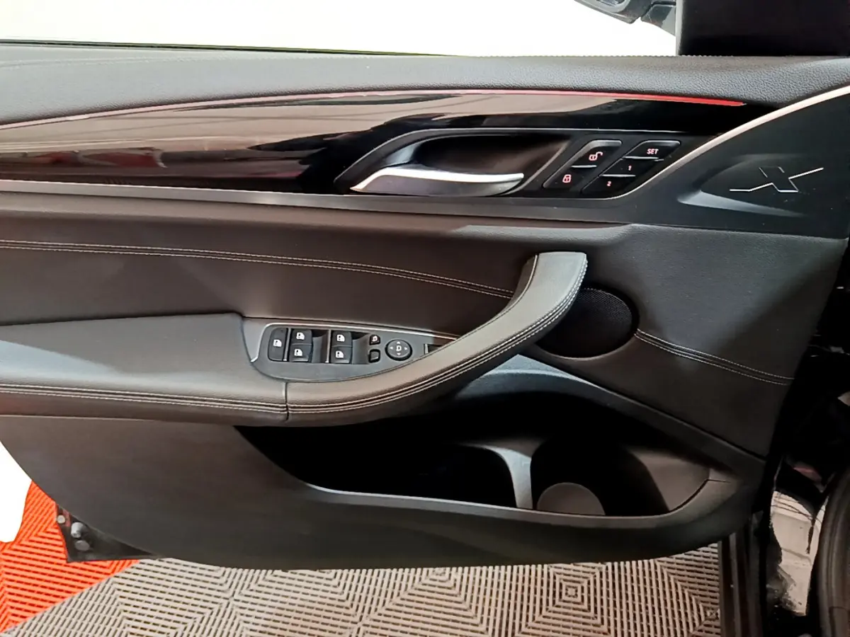 Intérieur côté gauche de la porte BMW X3 xDrive20d 2019 noire, avec commandes de vitres et insert brillant noir.