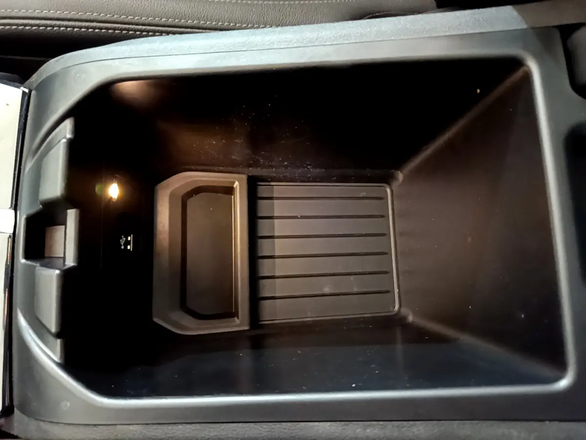 Vue plongeante sur le rangement central noir intérieur du BMW X3 xDrive20d 2019 avec prise USB et éclairage intégré.